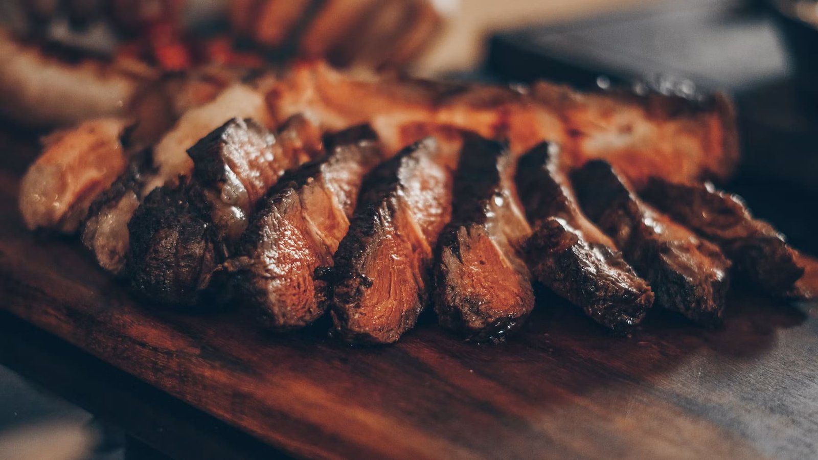 Premium steak grilling over open woodfire at Gaucho Argentinian steakhouse in Kuta, Lombok